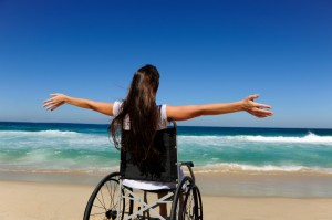 woman in wheelchair enjoying summer vacation on the beach